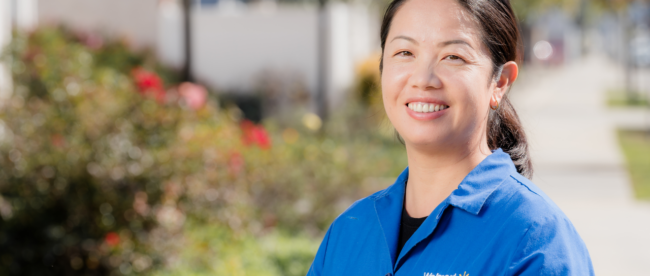 Caixia Jiang poses in front of Torrance Adult School. Her story demonstrates the impact of adult schools.