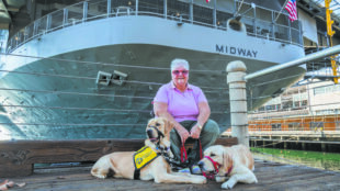 Photo of a veteran and her two dogs who were part of a service dog training organization